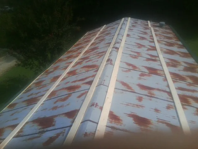 Rusted metal roof panels with new wood purlins before replacement — Storm Damage Roof Repair in Kemah by Roofing Brothers