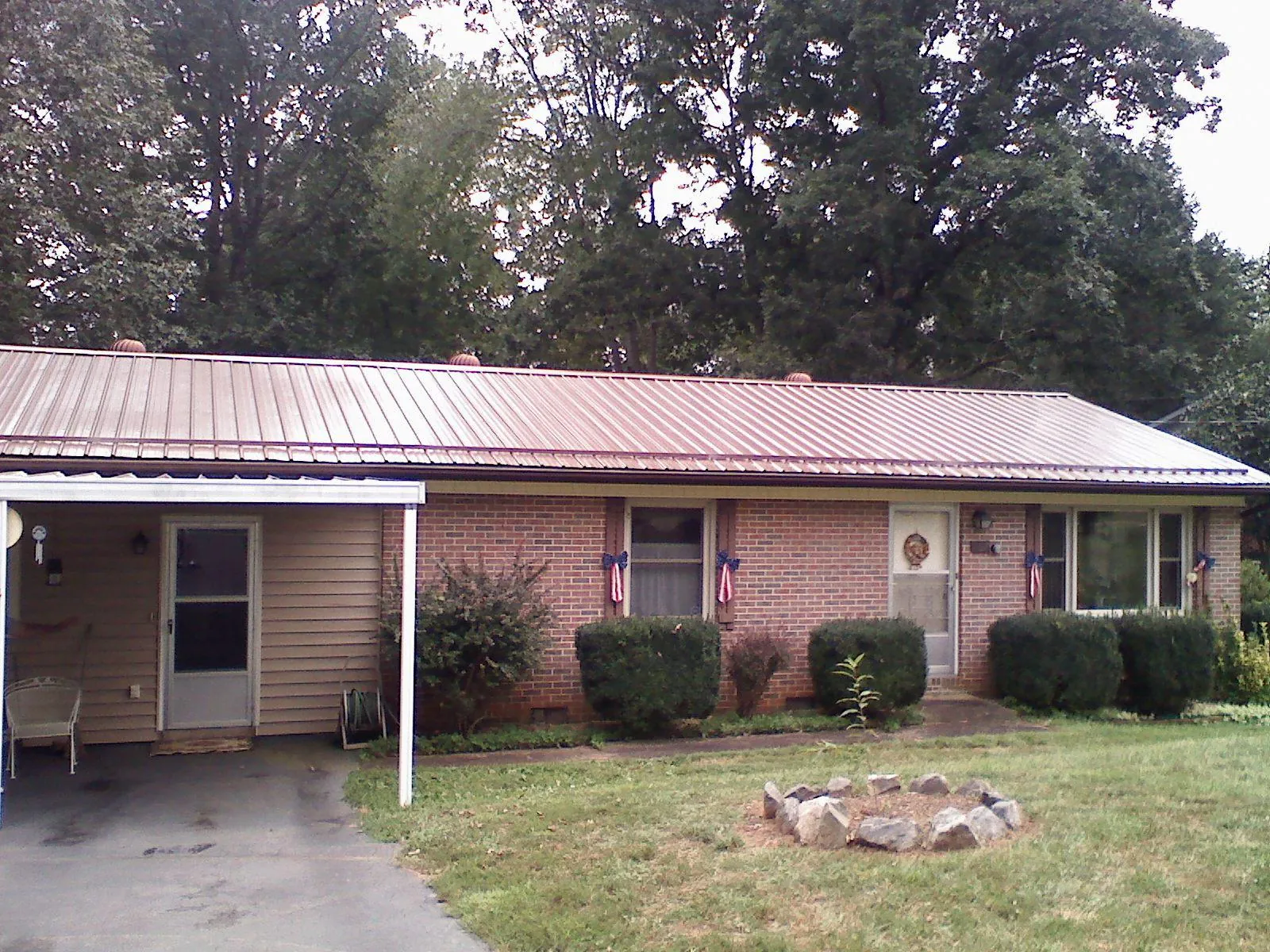 Bronze metal roof and carport on a brick ranch home — Roof Repair work by our crew in Kemah