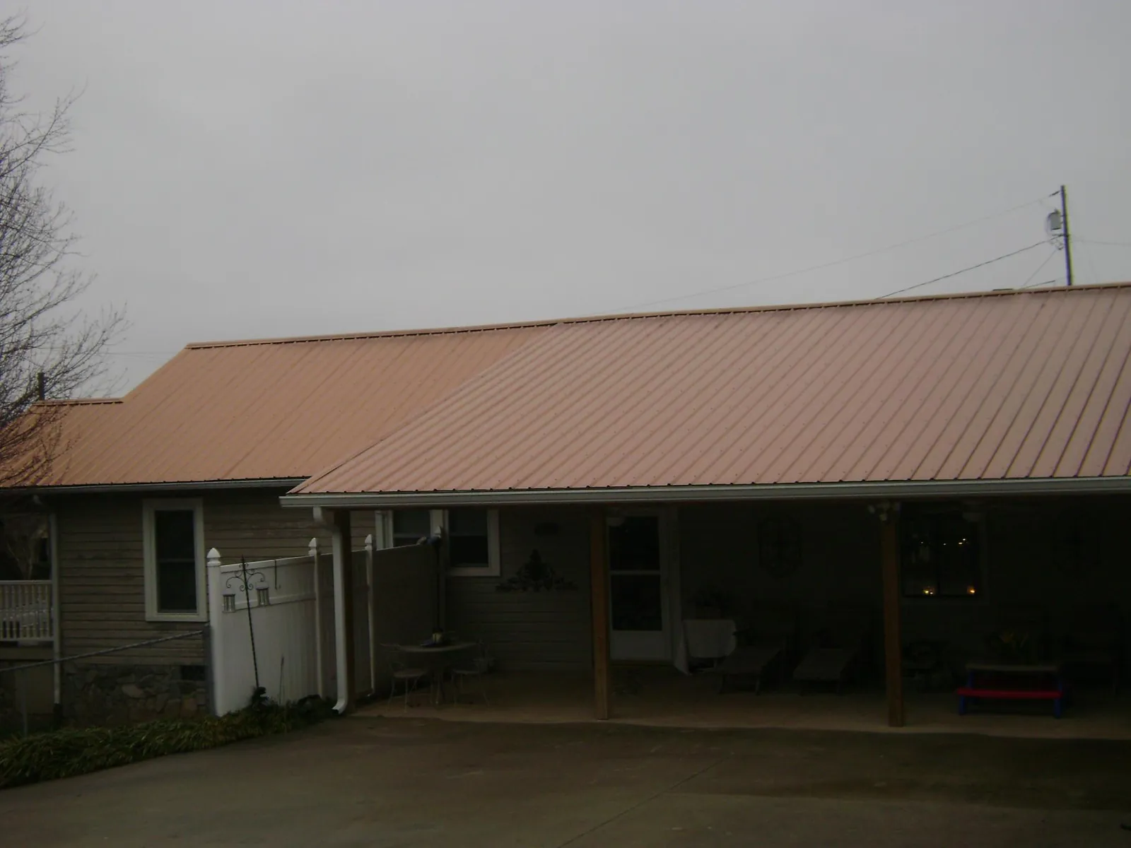Copper toned metal roof over a wide covered patio in Kemah